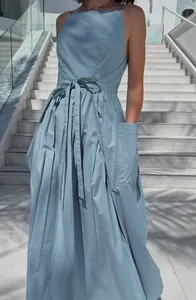 Detail view of a light blue sleeveless sundress with a large side pocket and tie waist detail