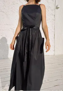 Elegant sleeveless black sun dress featuring a waist tie and functional side pockets