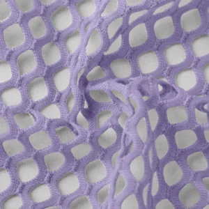 Close-up macro view of premium purple hollow-out mesh fabric for women's designer dress