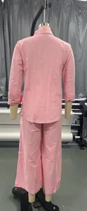 Vista posteriore di un set rosa da donna in due pezzi con camicia a maniche lunghe e pantaloni larghi