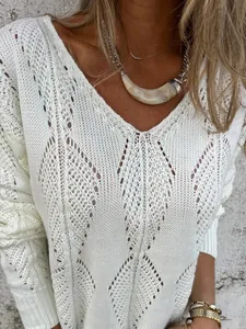 Detail view of white knit sweater with hollow-out leaf pattern and V-neck design