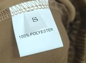 Gros plan de l'étiquette blanche indiquant la taille S et la composition 100% polyester.
