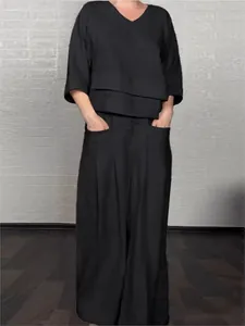 Elegant black two-piece set featuring a loose V-neck top and wide-leg trousers with pockets