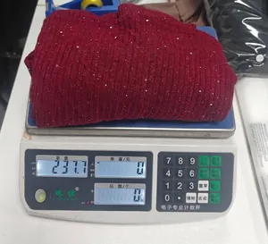 Misurazione del peso di un maglione bordeaux scintillante su una bilancia digitale