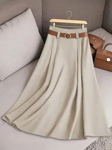 Détail rapproché d'une élégante jupe plissée évasée kaki avec une ceinture marron stylée