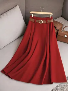 Vue détaillée d'une jupe mi-longue plissée rouge foncé avec une ceinture en cuir marron