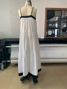 Back view of white tiered spaghetti strap maxi dress with black contrast trim on mannequin