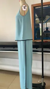 Detailed side view of sleeveless light blue top and wide-leg pants set with black trim