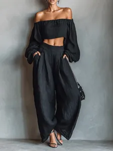 Elegant black off-the-shoulder two-piece set with long sleeves and wide-leg trousers