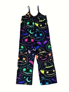 Detail des Halloween-Jumpsuits mit Neon-Kürbis- und Hexenhut-Prints auf schwarzem Stoff.