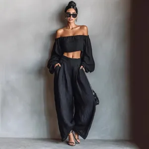 Chic black two-piece set featuring off-shoulder puff sleeve crop top and wide-leg trousers