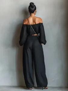 Rear view of an elegant black off-shoulder crop top and wide-leg pants set.