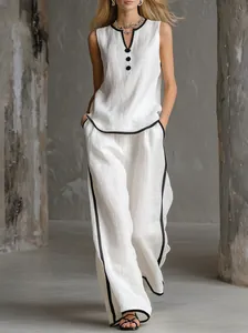 Dettaglio completo di set in lino bianco con profili neri e pantaloni a gamba larga