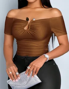 Close-up of off-the-shoulder ruched top with metallic buckle detail on tan model.