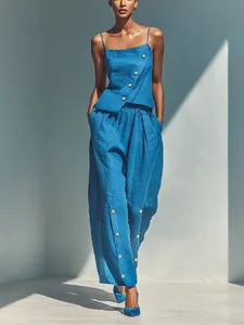 Elegant blue two-piece set featuring asymmetrical button camisole and wide-leg trousers.