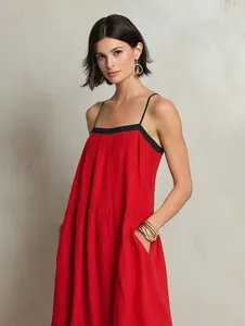 Detail of a red European style slip dress with black straps and side pockets