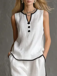 Elegante top bianco senza maniche con scollo a V e finiture nere e pantaloni in lino