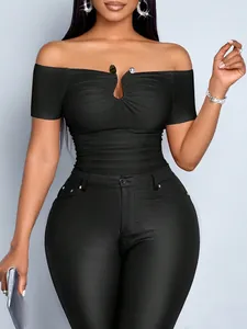 Detailed close-up of a black off-the-shoulder ruched top with a metal buckle detail