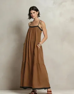 Full length view of elegant brown tiered spaghetti strap maxi dress with black trim