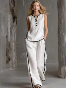 Detailed view of a white minimalist two-piece set featuring elegant black piping details