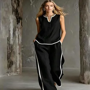 Elegant sleeveless V-neck black top with white trim and matching wide-leg trousers set