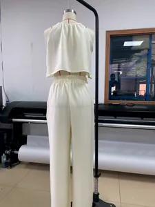 Vista trasera de un conjunto bohemio crema de top halter y pantalones anchos en maniquí