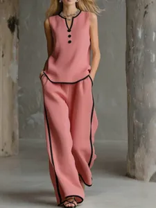 Elegant pink sleeveless V-neck top and wide-leg pants set with black contrast piping