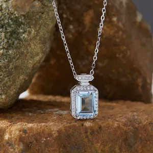 Detail of square blue topaz pendant on S925 silver chain with halo setting