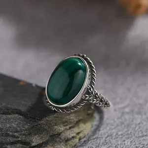 Primer plano de un anillo vintage de plata S925 con malaquita ovalada y hojas talladas