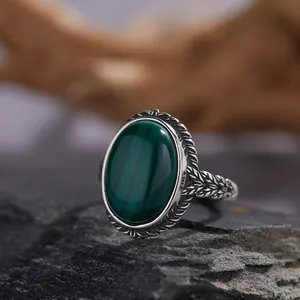 Detalle de un anillo de plata S925 vintage con malaquita ovalada y patrones grabados.