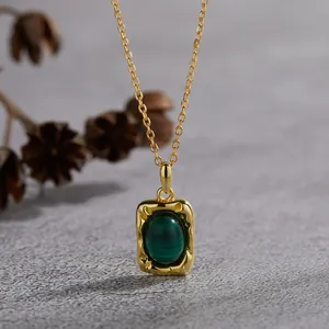Close-up of vintage gold-plated malachite pendant with hammered texture detail