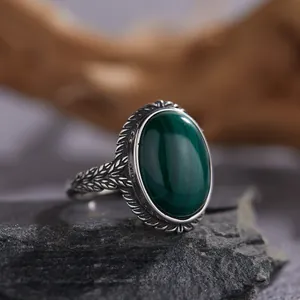 Primer plano de un anillo de plata vintage con una malaquita verde óvalo pulida