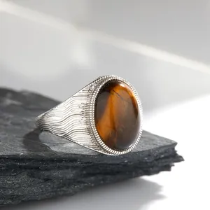 Dettaglio di un anello in argento con occhio di tigre naturale ovale e fascia ondulata