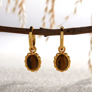 Close-up detail of high-quality gold hoop earrings with natural tiger eye stones