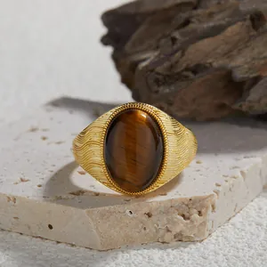 Primo piano di anello vintage in argento dorato con una grande pietra occhio di tigre ovale