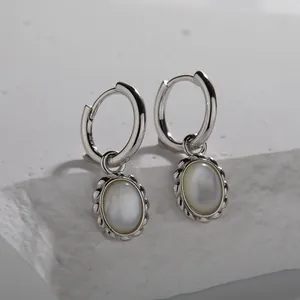 Detailed macro view of S925 sterling silver hoop earrings featuring oval white shell charms