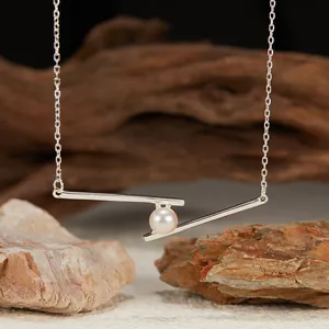 Close-up of S925 silver geometric bar pendant featuring a lustrous natural pearl.
