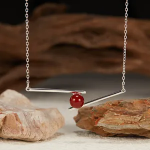 Close-up detail of S925 silver geometric bar pendant necklace with red agate bead