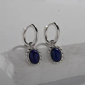 Macro view of French style S925 sterling silver hoop earrings with oval lapis lazuli