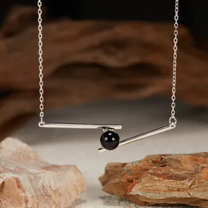 Detailed view of S925 silver necklace featuring a black agate bead on a geometric bar