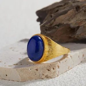 Primo piano di un lapislazzuli ovale incastonato in un anello d'oro con texture.