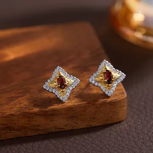Dettaglio di orecchini a stella in argento S925 con granato rosso in stile vintage