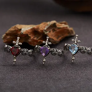 Close-up of S925 silver gothic rings with heart gemstones, cross and rose details.
