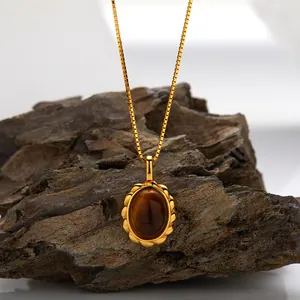 High-detail close-up of a tiger eye stone pendant on a textured dark rock background