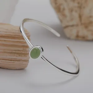 Detailansicht eines eleganten 925er Sterlingsilber-Armreifs mit grünem Edelstein.