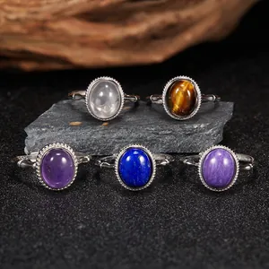 Macro view of five S925 silver rings set with diverse natural gemstones on stone base