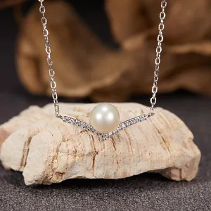 Close-up of V-shaped sterling silver necklace with central pearl and pavé stones