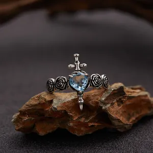 Close-up detail of a vintage S925 silver ring with blue topaz heart and cross sword