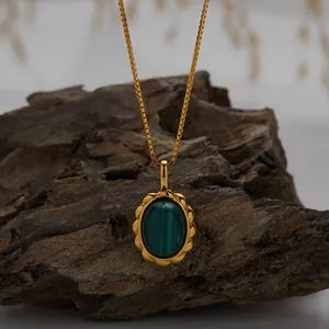 Detailed macro shot of gold box chain necklace with oval green malachite gemstone