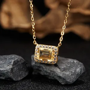 Macro detail of elegant gold necklace pendant with rectangular yellow citrine gemstone